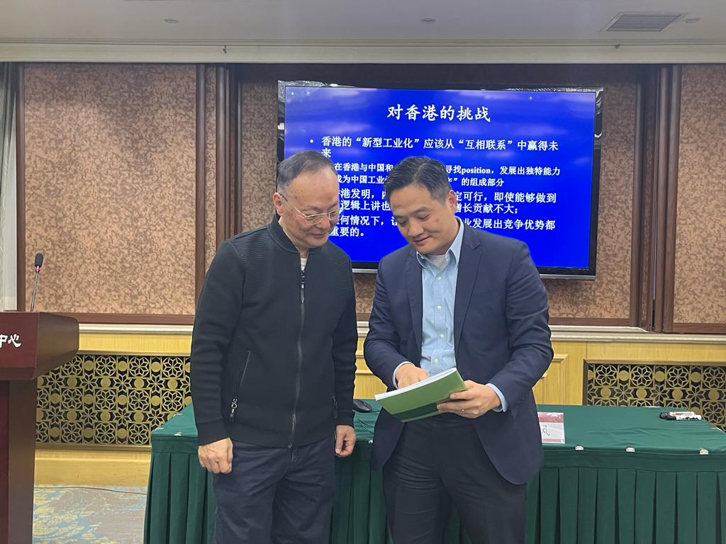 黄元山博士向其中一位讲者北京大学政府管理学院政治经济学系教授路风赠送行政长官最新一份《施政报告》及封面印有「同为香港开新篇」的笔记本。